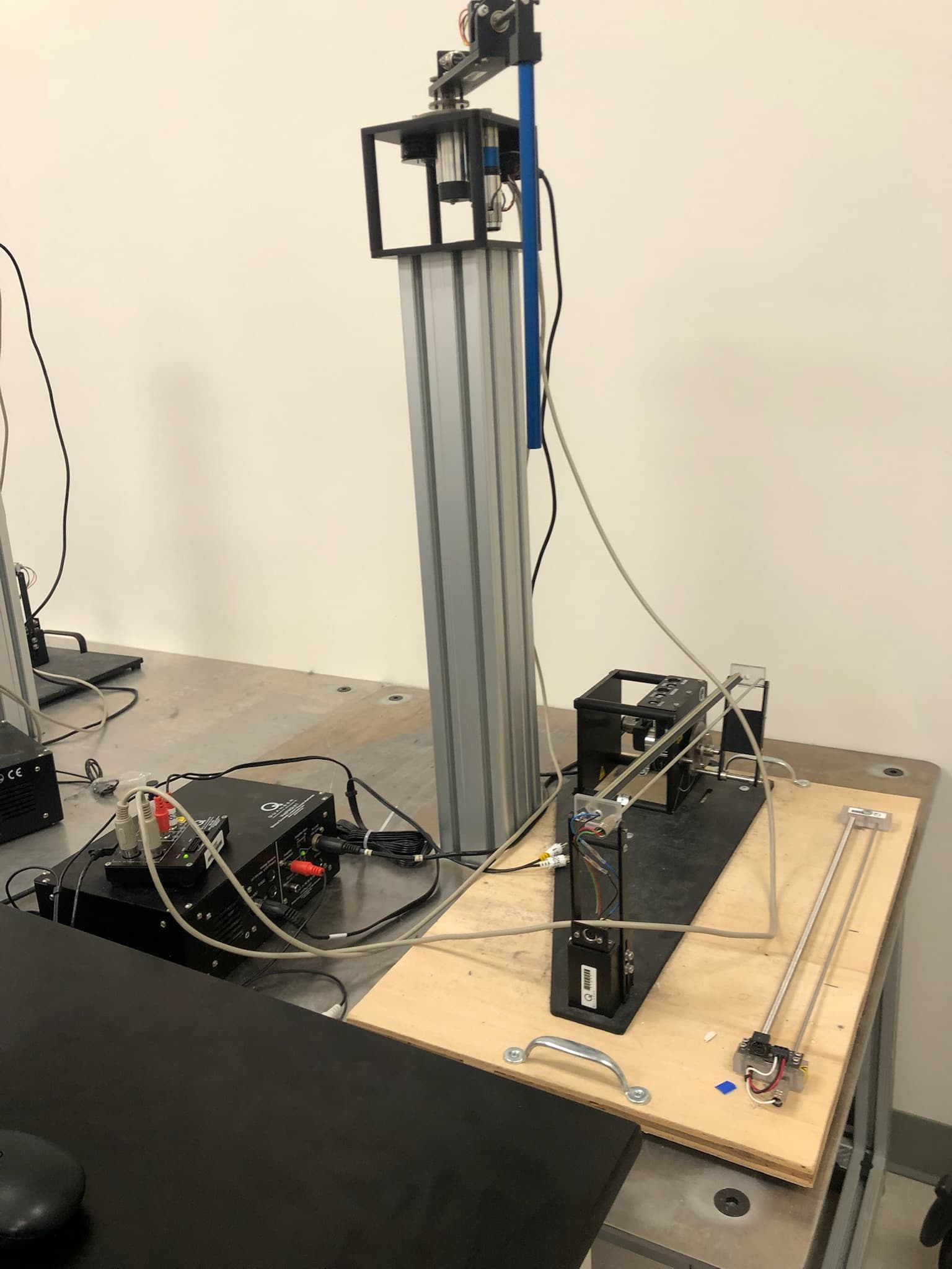 Rotary inverted pendulum laboratory rig with pendulum arm, encoder wiring, amplifier, and HIL hardware